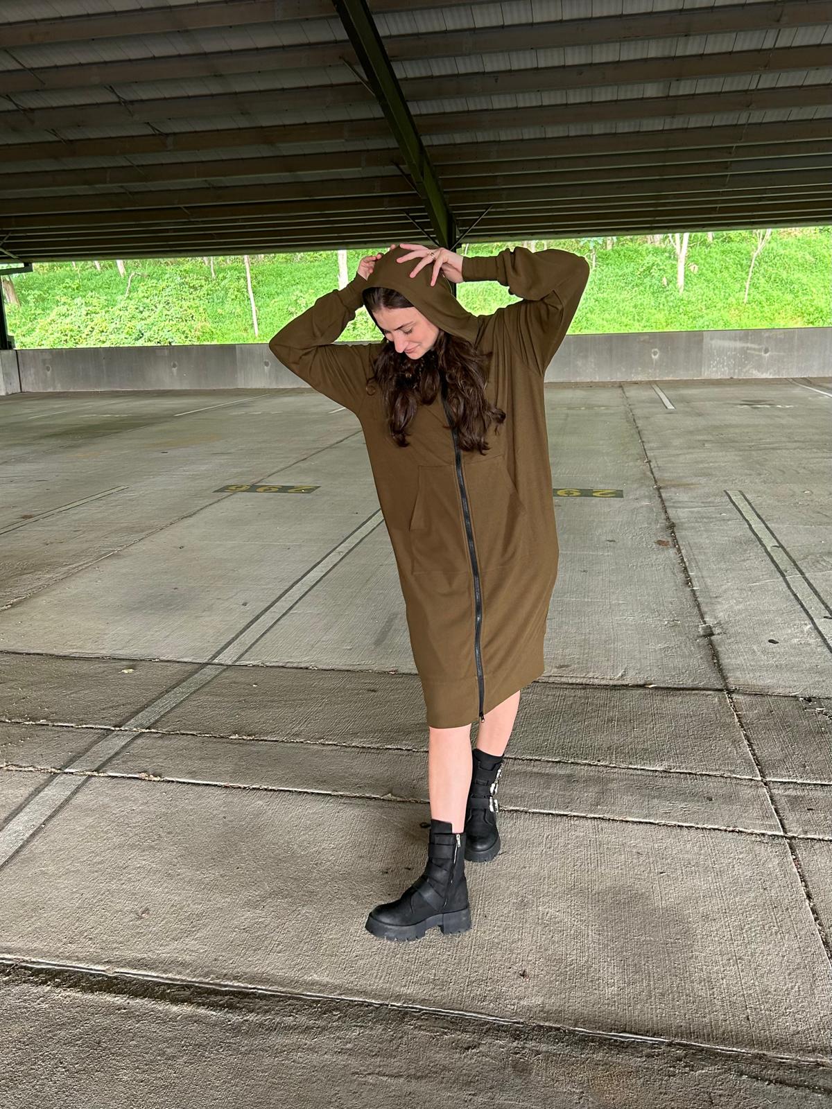 brown hair model in parking garage wearing modest olive green zip dress with chunky boots